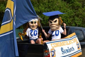 Line leaders: Mascots Lumberjack and Lumberjill, Mrs. Heidi Edwards, cheer coordinator, and Mrs. Kathy Barlow, cheer coach, rode in the bed of a pickup truck and led seniors during the parade. Photo by: The Ax Staff
