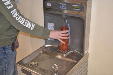 Water Wellness: A student utilizes the schools water bottle dispensers to refill during the day. Alex Brouhard, psychology teacher, said, Dehydration can have an adverse effect on our moods, how we think, and our energy levels. Photo illustration by: Max Kiernan. 