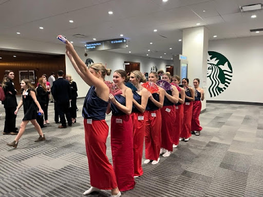 Lights, Camera, Action: Ella Pleiman (12), Anna Newman(10) , Clara Smith (12), Kennedy Nels (11), Maggie Sollenburger (12), Brigid Newman (10), Annie Mhaskar (10) and Faye Foley (12) perform a traditional dance from North Korea hoping to score an award for their performance and spread culture. “My favorite thing about OMUN is meeting students from other schools while representing all of our different nations,” Calista Styles (11) said. Photo contributed by: Heather McGlothen