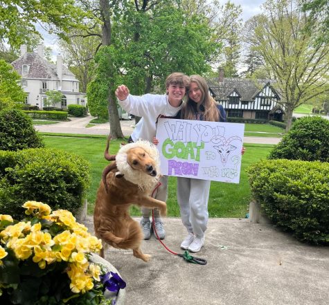 Goating to Prom: Patrick Bremner (11) gives his promposal sign to his date, Claudia Butler (11), with the help of his dog, who is dressed up as a goat. Photo contributed by: Patrick Bremner
